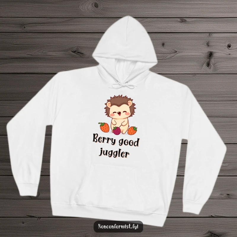 Funny hoodie featuring an unconventional hedgehog character wiggling playfully while juggling three mismatched berries, warm and whimsical apparel.