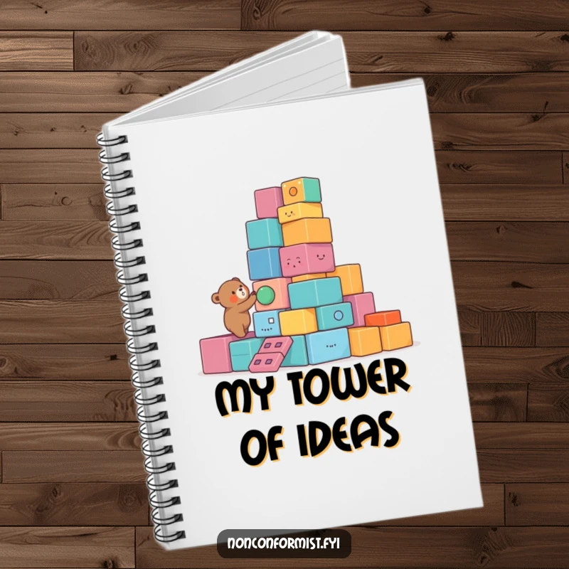 Funny Bear Notebook with a small bear character building a lopsided tower of colorful, unusual blocks, perfect for notes with humorous flair.